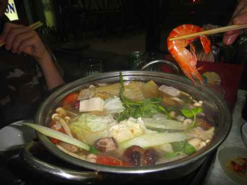 Lifting a prawn from a hotpot, Cam Chi Alley, Hanoi, Vietnam